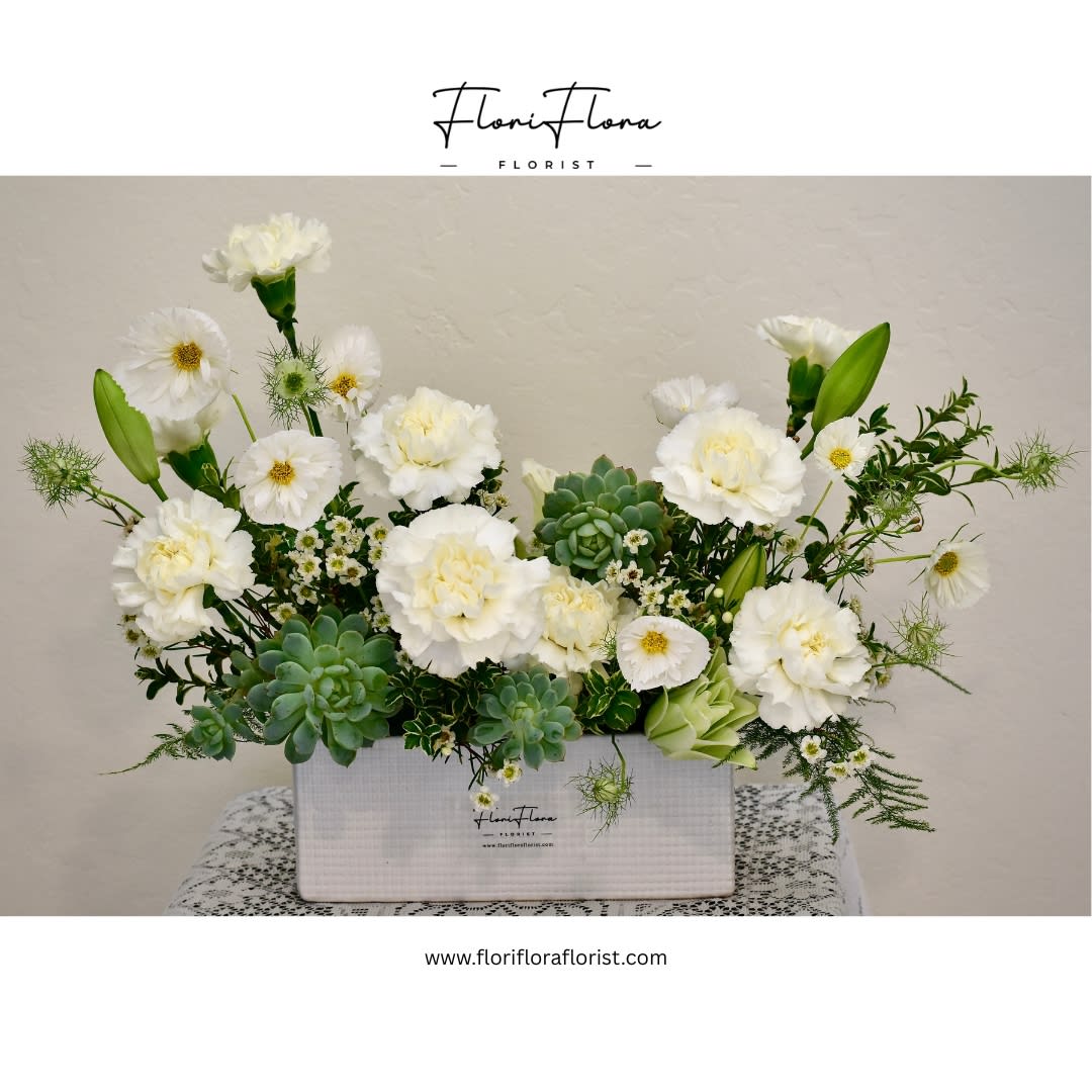 Carnation's Greeting - Carnation’s Greeting is a refreshing arrangement that blends the timeless charm of pure white carnations with the modern elegance of succulents. The soft ruffled petals symbolize love and admiration, while the lush greens bring a touch of serenity and lasting beauty. Together, they create a thoughtful gift that conveys warmth, grace, and a heartfelt welcome for any occasion.