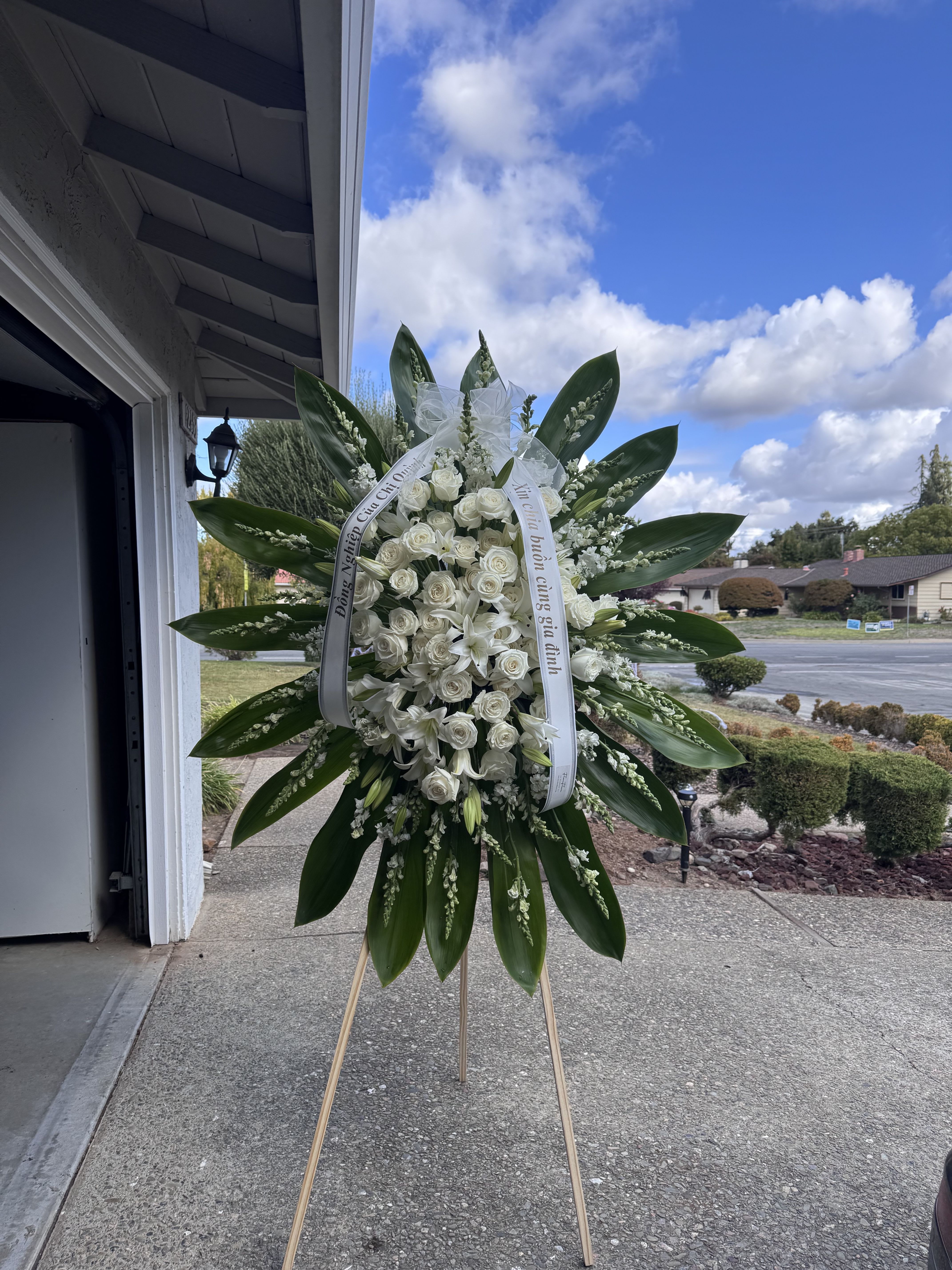White Roses and Lilies Standing Spray - Include: - 1 wooden stand 66 inches - 2 free Banners with Hand- Written (Max 8 Words each Banner) To Add BANNER MESSAGES ===Please Copy and Paste Below into "Special Instruction" box === Banner 1: (message here) Banner 2: (message here)  *****Please note that this wreath has to order in advance 2 days before delivery date.*****
