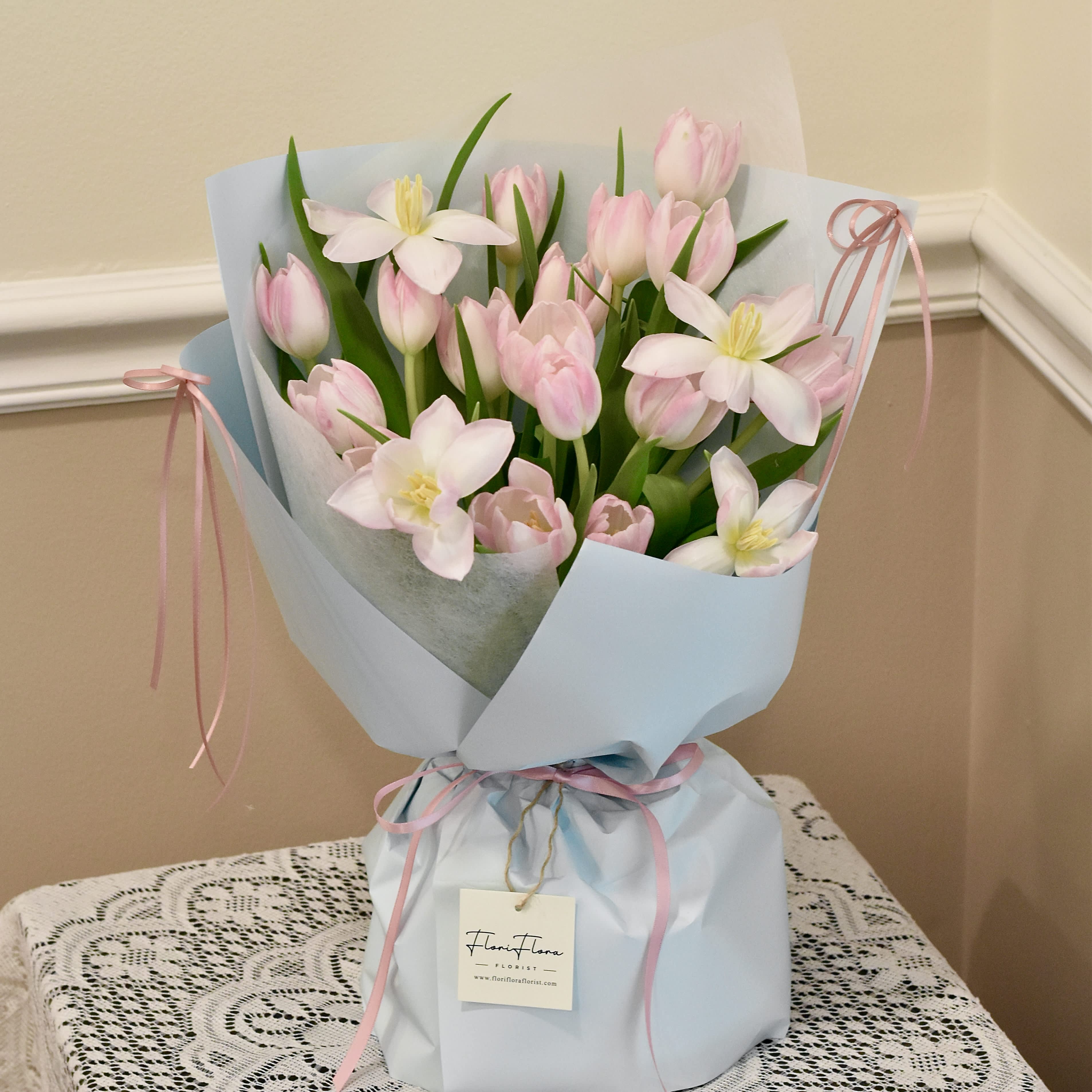 Tulip's Poem - ***** If you prefer flowers in a different color palette, please indicate your preference in the special instructions box.*****  A tulip bouquet is a vibrant and enchanting arrangement of tulip flowers, renowned for their elegance and charm. Typically, these bouquets feature a variety of tulip colors, ranging from vibrant reds, yellows, and oranges to delicate pinks, purples, and whites, each adding its own unique flair to the ensemble.  Tulips are known for their simple yet striking appearance, with slender stems and bold, cup-shaped blooms. Their petals can be smooth and glossy, with a slight sheen that adds to their allure. Depending on the arrangement, the bouquet may showcase tulips of uniform color for a clean and sophisticated look, or it might incorporate a mix of hues for a more dynamic and lively display.  A tulip bouquet exudes a sense of freshness and vitality, making it a popular choice for various occasions, from weddings and birthdays to anniversaries and celebrations of all kinds. Whether presented as a romantic gesture or as a token of appreciation, a tulip bouquet never fails to captivate with its beauty and simplicity.