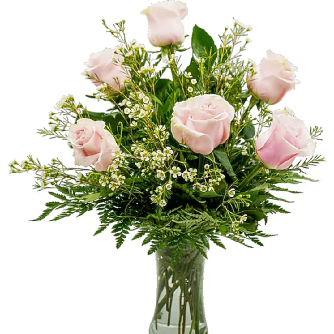 Light pink roses arranged in a clear glass vase with greenery