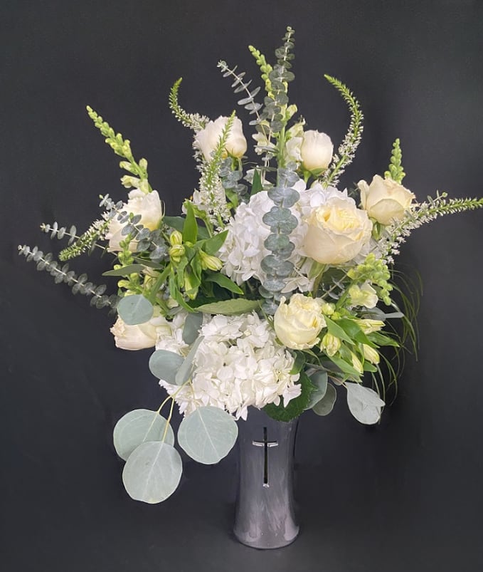 Silver Sympathy Cross Vase - An elegant silver vase with a etched cross design is filled with fresh white flowers including hydrangeas, roses, lilies, snapdragons, and alstro.