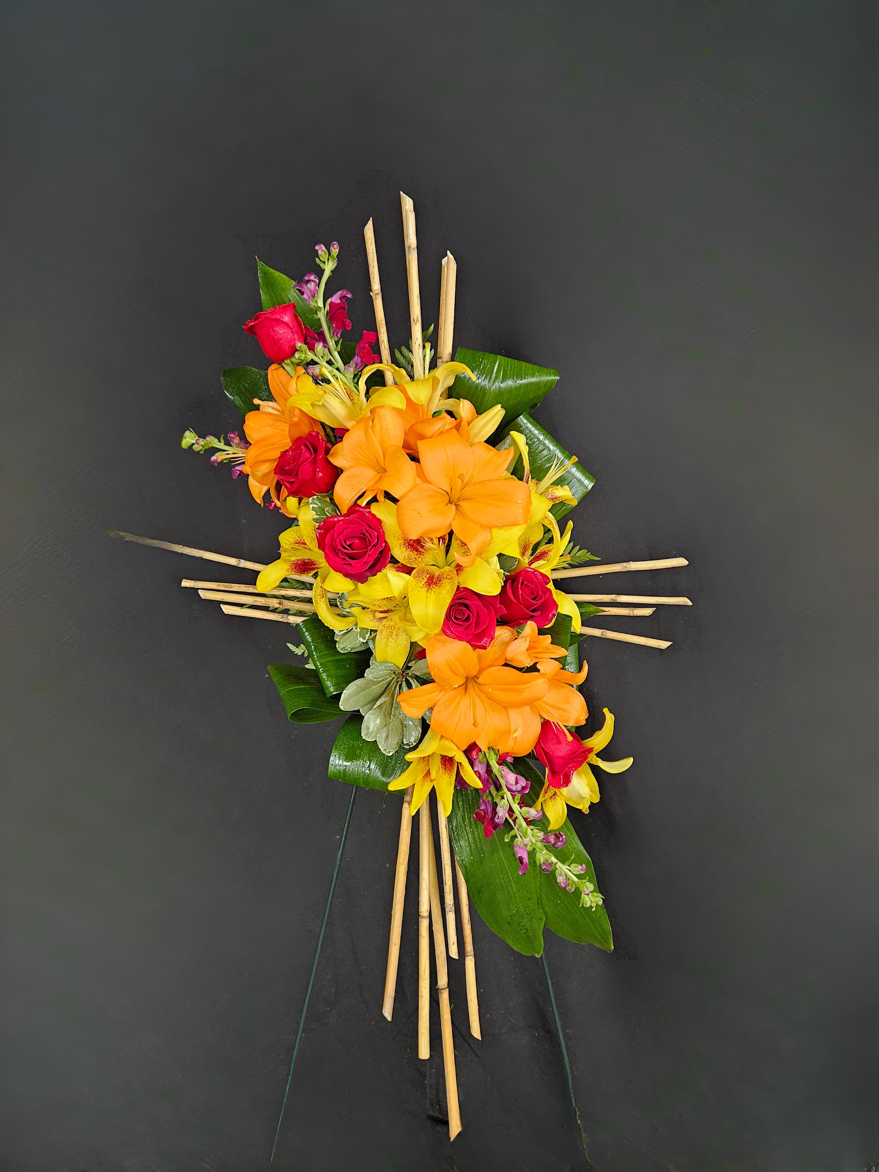 Compassionate Bamboo Cross Standing Spray  - A standing spray consisting of a bamboo cross decorated with an artistic floral design. Arrangement is mounted on a 4.5ft standing easel for prominent display at funeral services.