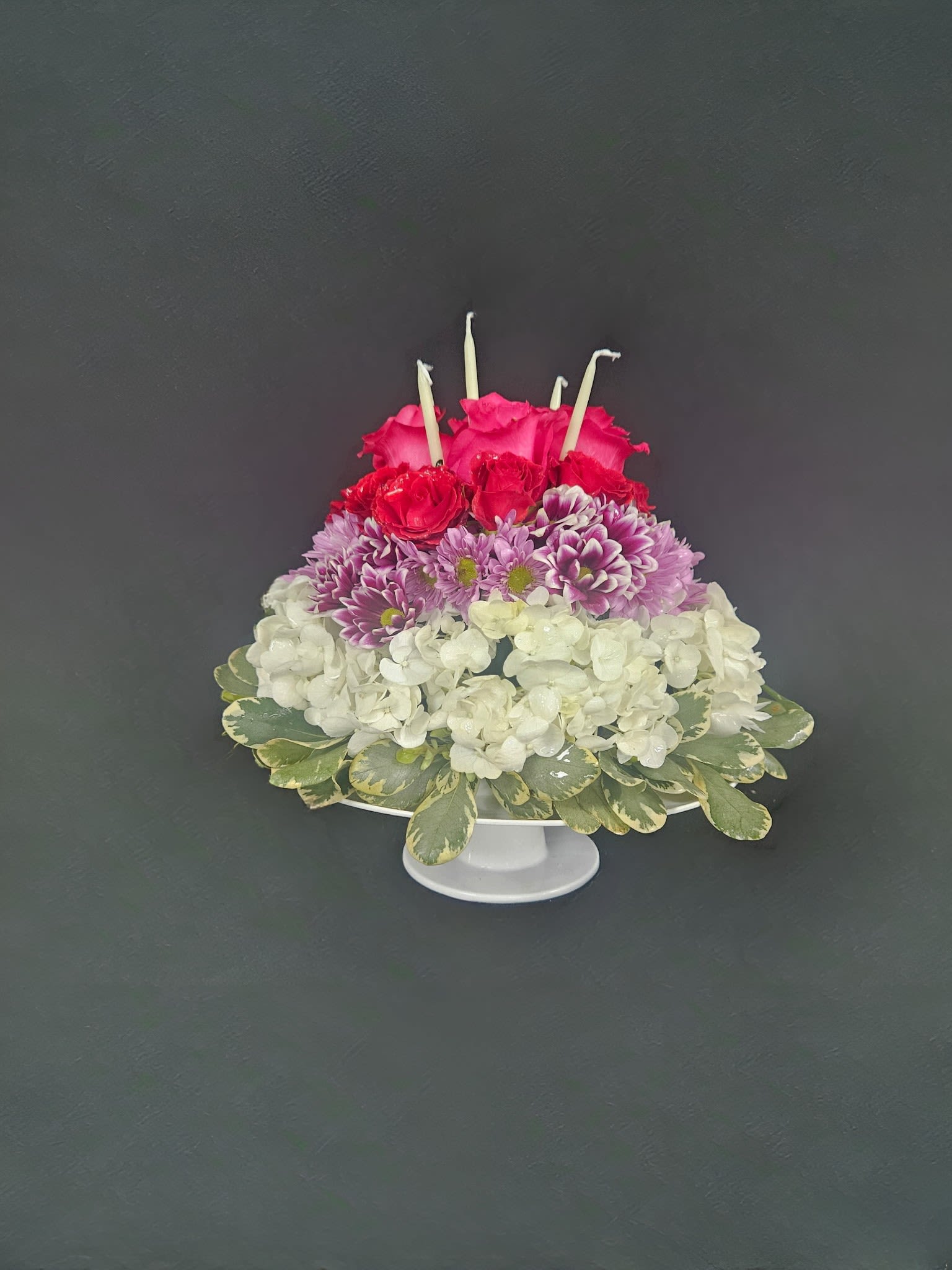 Floral Birthday Cake - Celebrate a special birthday with a special cake... a flower cake! This cake shaped form is covered in button poms, mini carnations, and alstro with a rose topper. Includes real birthday candles to complete the look.