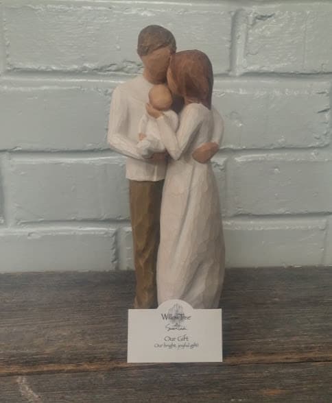 Wooden figurine of a couple holding a baby