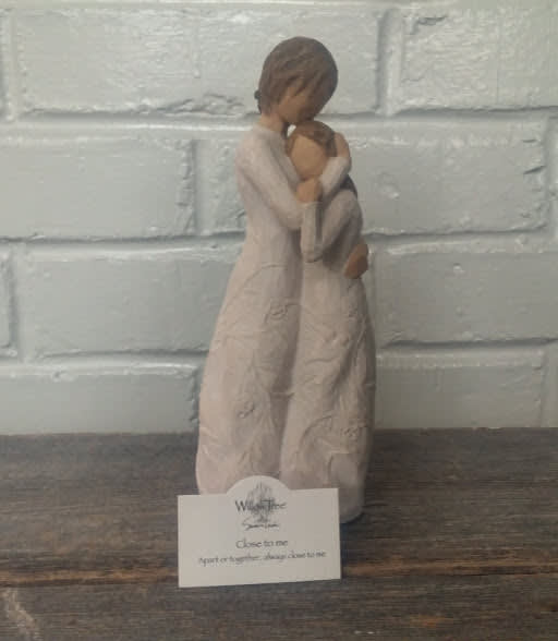 Two figurines embracing, with a small card in front