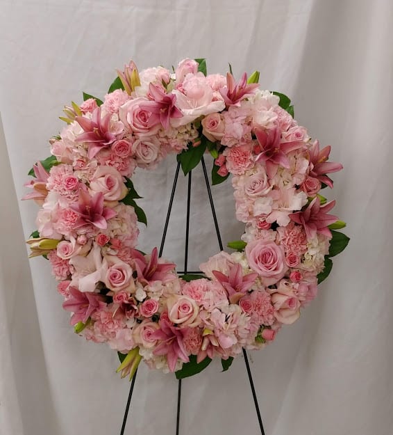 Serenity Wreath  - A ring of pink blossoms will create a serene display at any funeral or wake. This classic wreath is delivered on an easel, and is a thoughtful expression of sympathy and admiration. 
