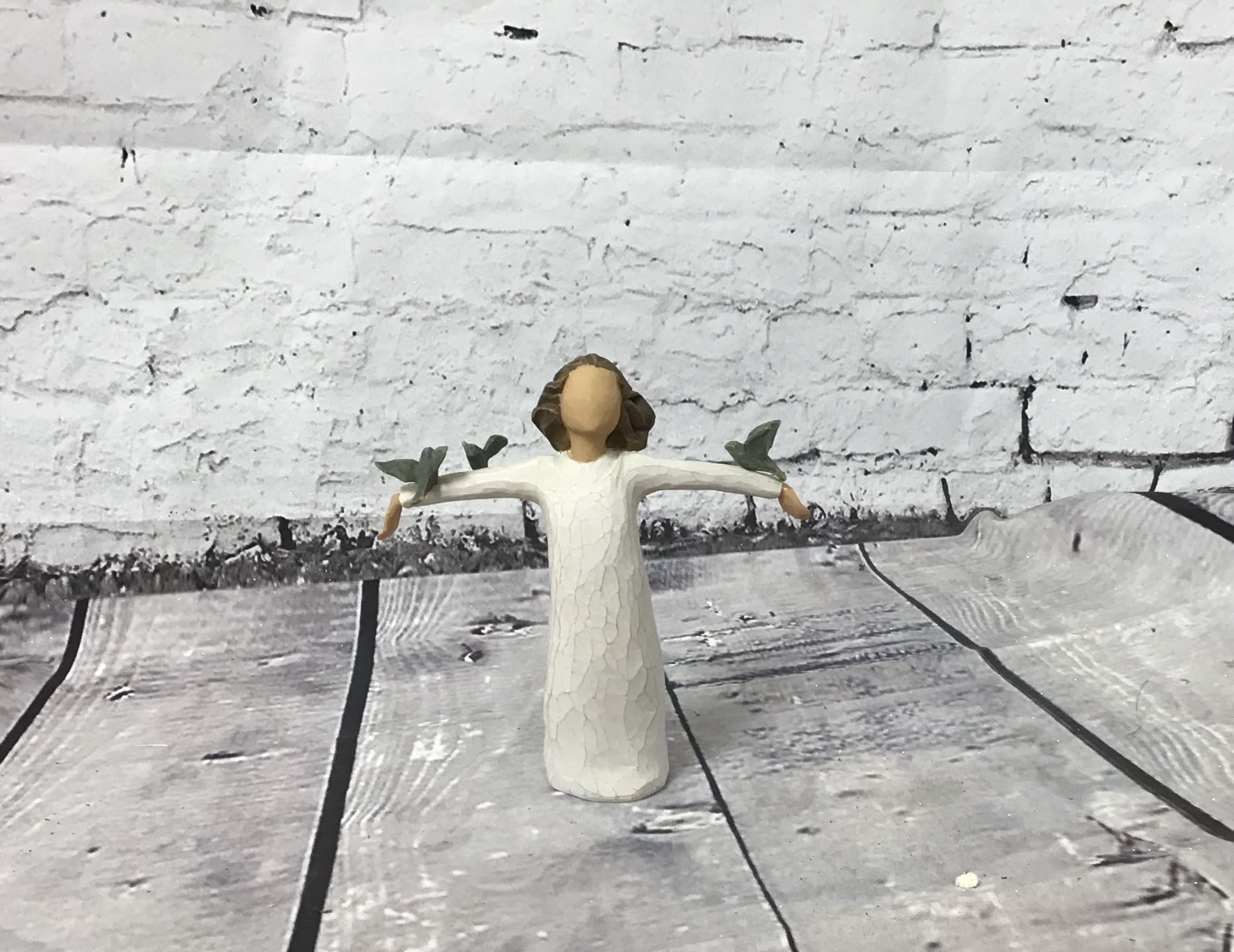 Small angel figurine in a white dress with outstretched arms