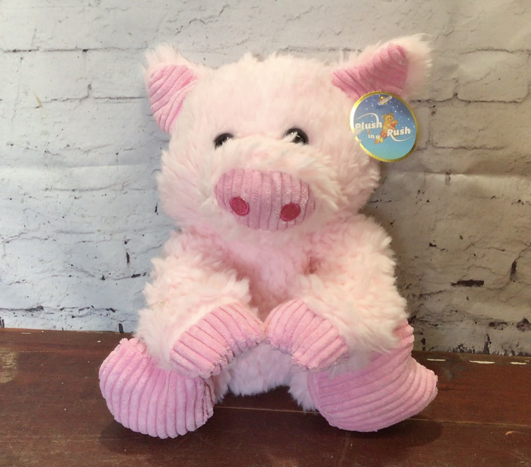 Pink plush pig toy with a tag attached