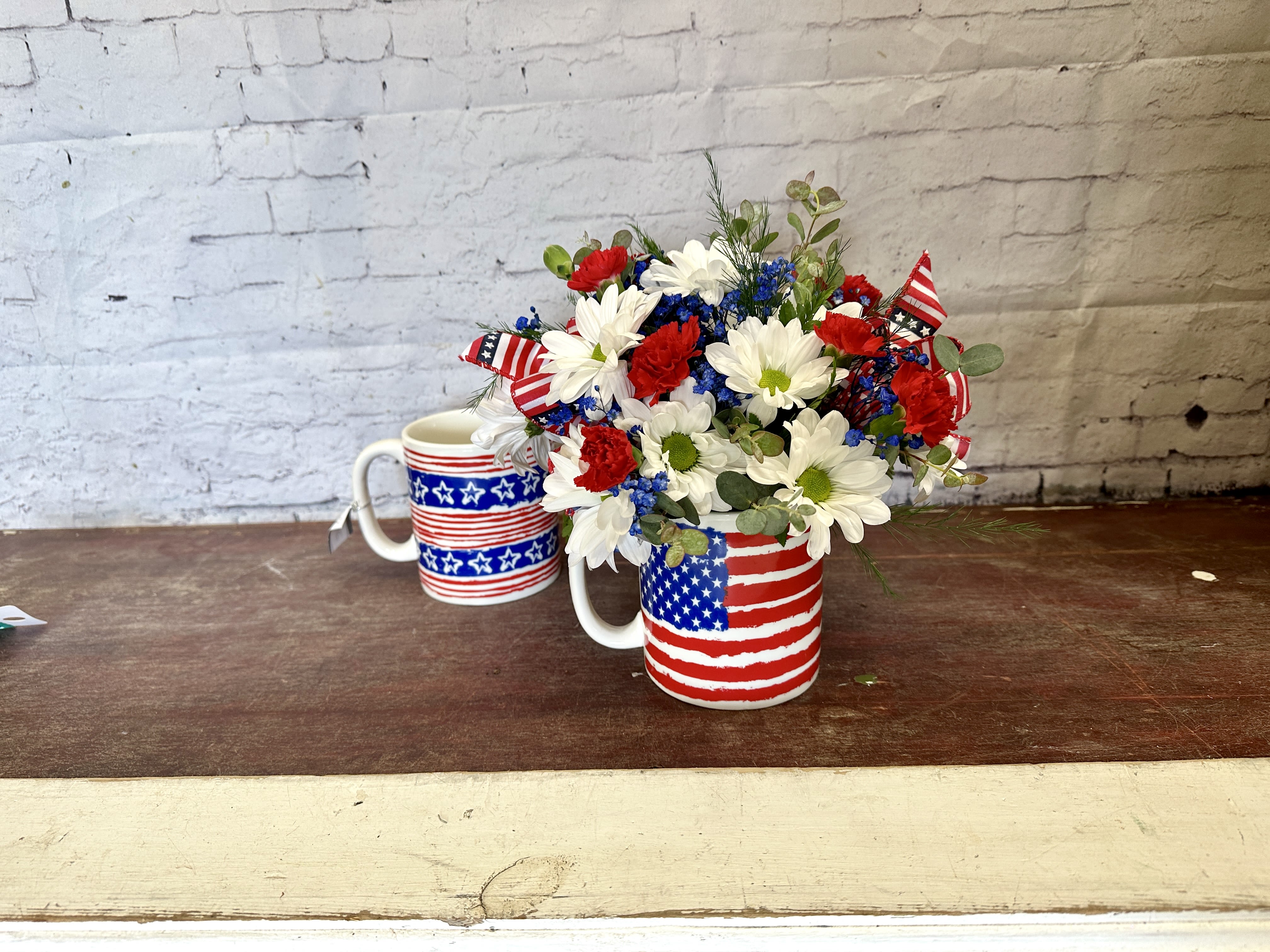 Stars, stripes, and stems  - Patriotic ceramic mug(may vary) with white daisies, red carnations, and blue filler blooms