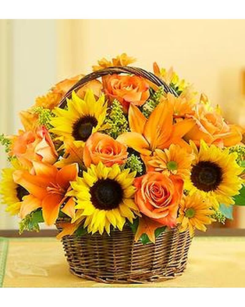 Basket of orange roses, sunflowers, and lilies