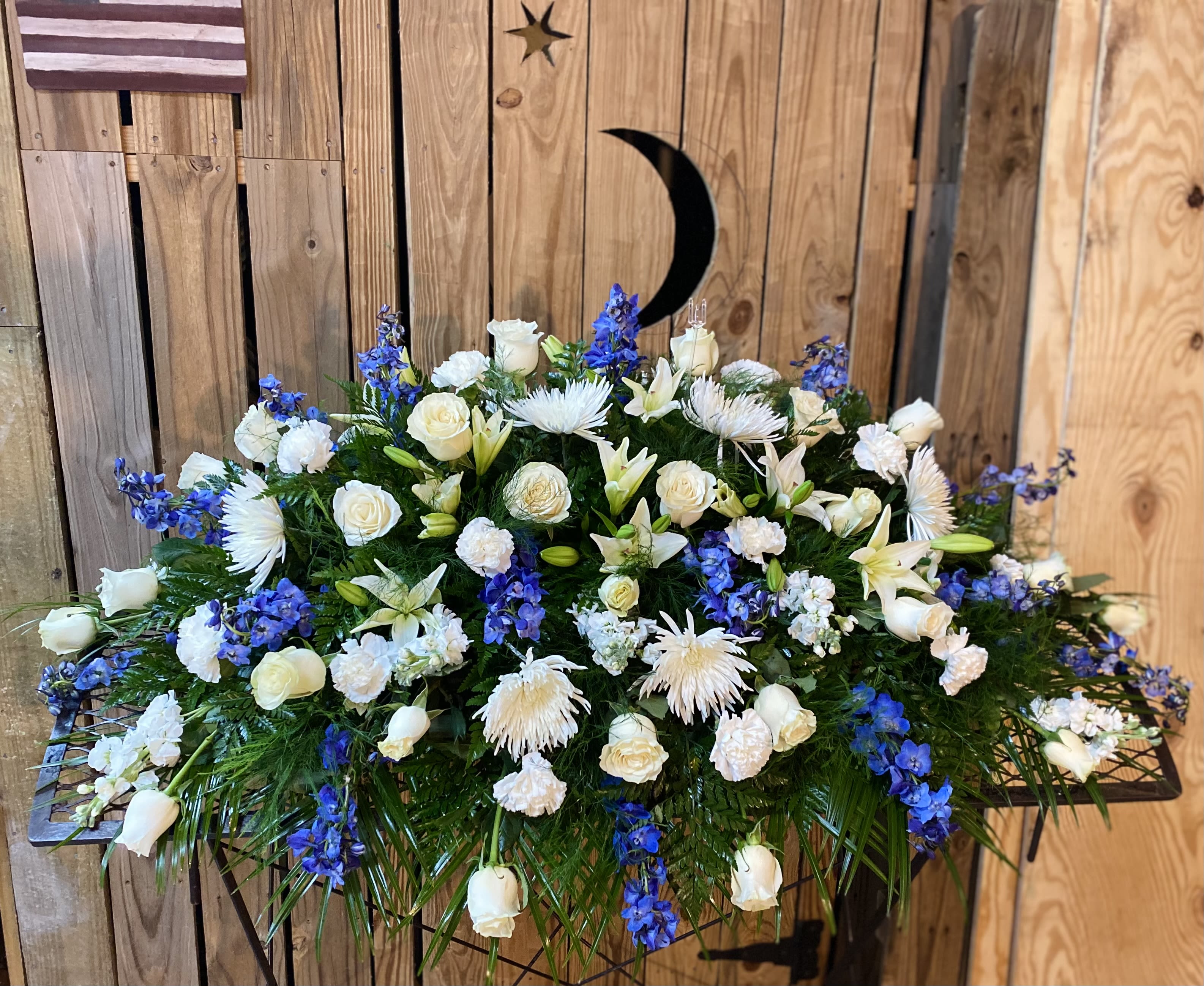 Large white and blue floral arrangement on a stand
