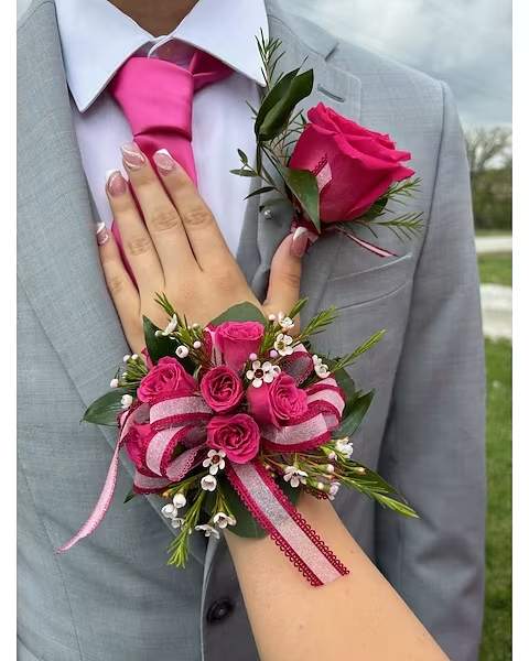 Pink rose boutonniere and wrist corsage on a gray suit