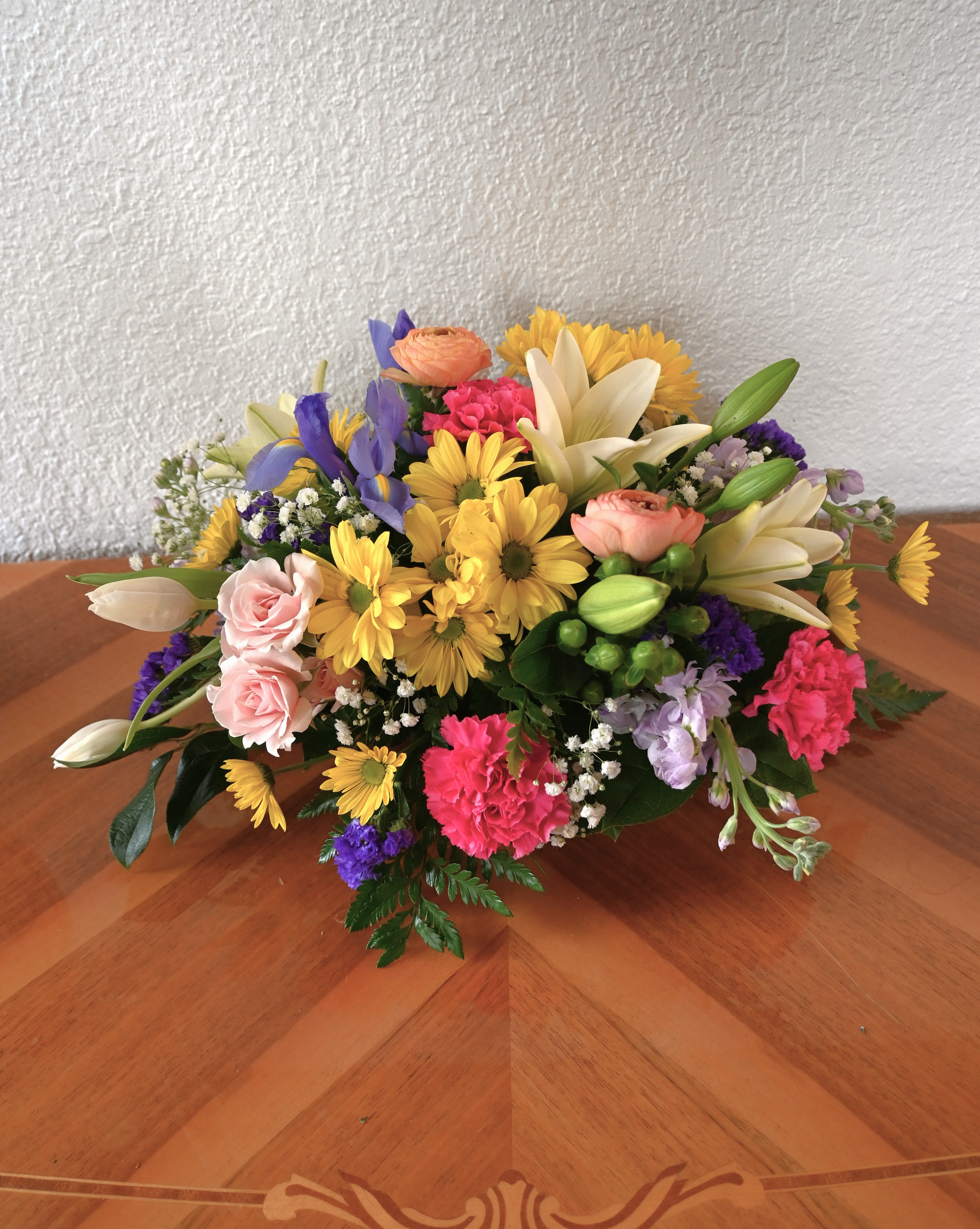Spring Garden Centerpiece - Adorn your table with fresh, seasonal blooms in an array of cheerful colors! Made with the freshest seasonal flowers, this seasonal centerpiece is perfect for bringing a touch of warmth and joy to any celebration.