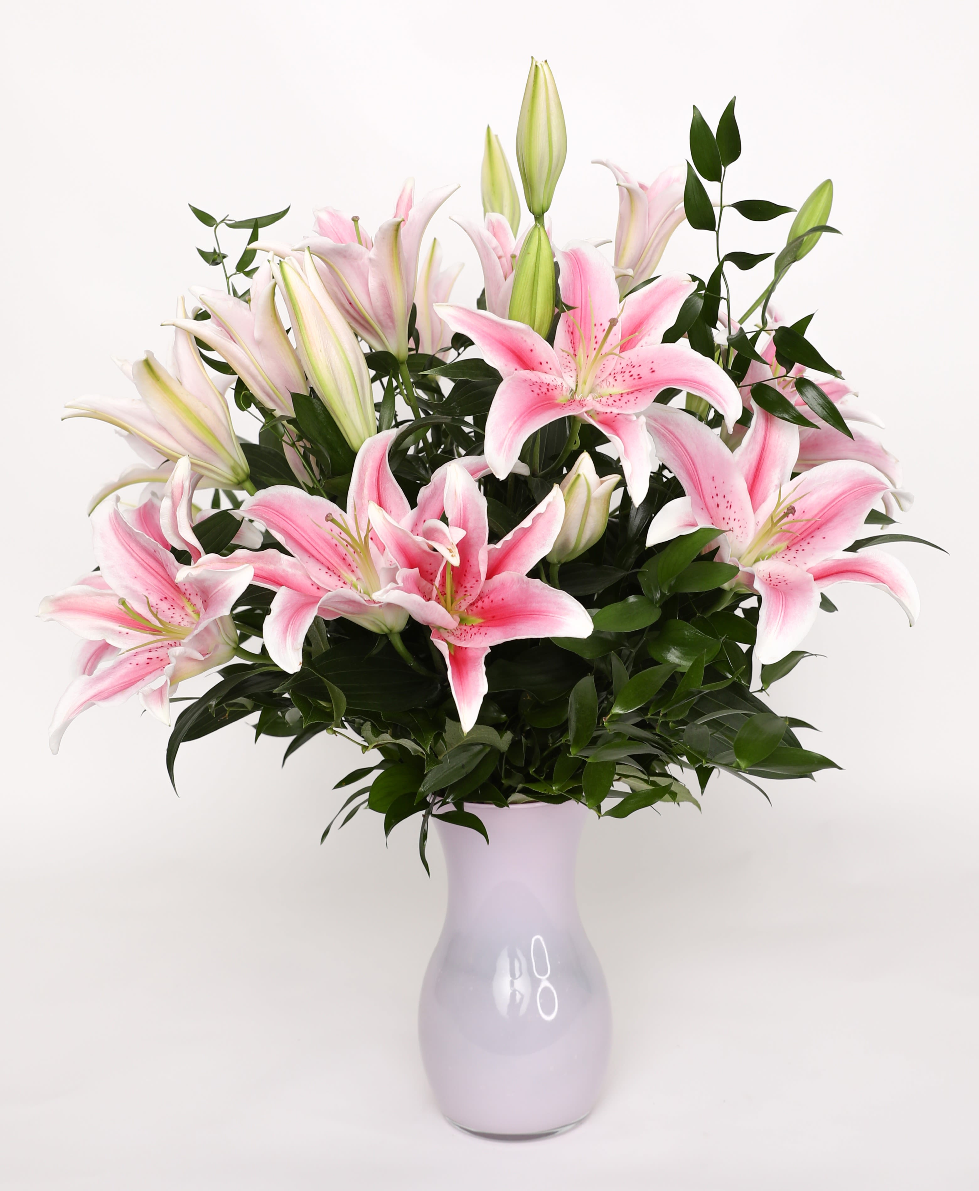 Pink lilies arranged in a lavender vase