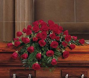 Red rose casket spray on a wooden casket