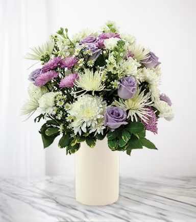 Lavender and white mixed bouquet in a cream vase