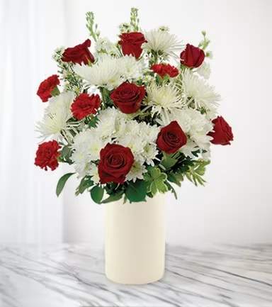 Red roses and white chrysanthemums in a cream vase