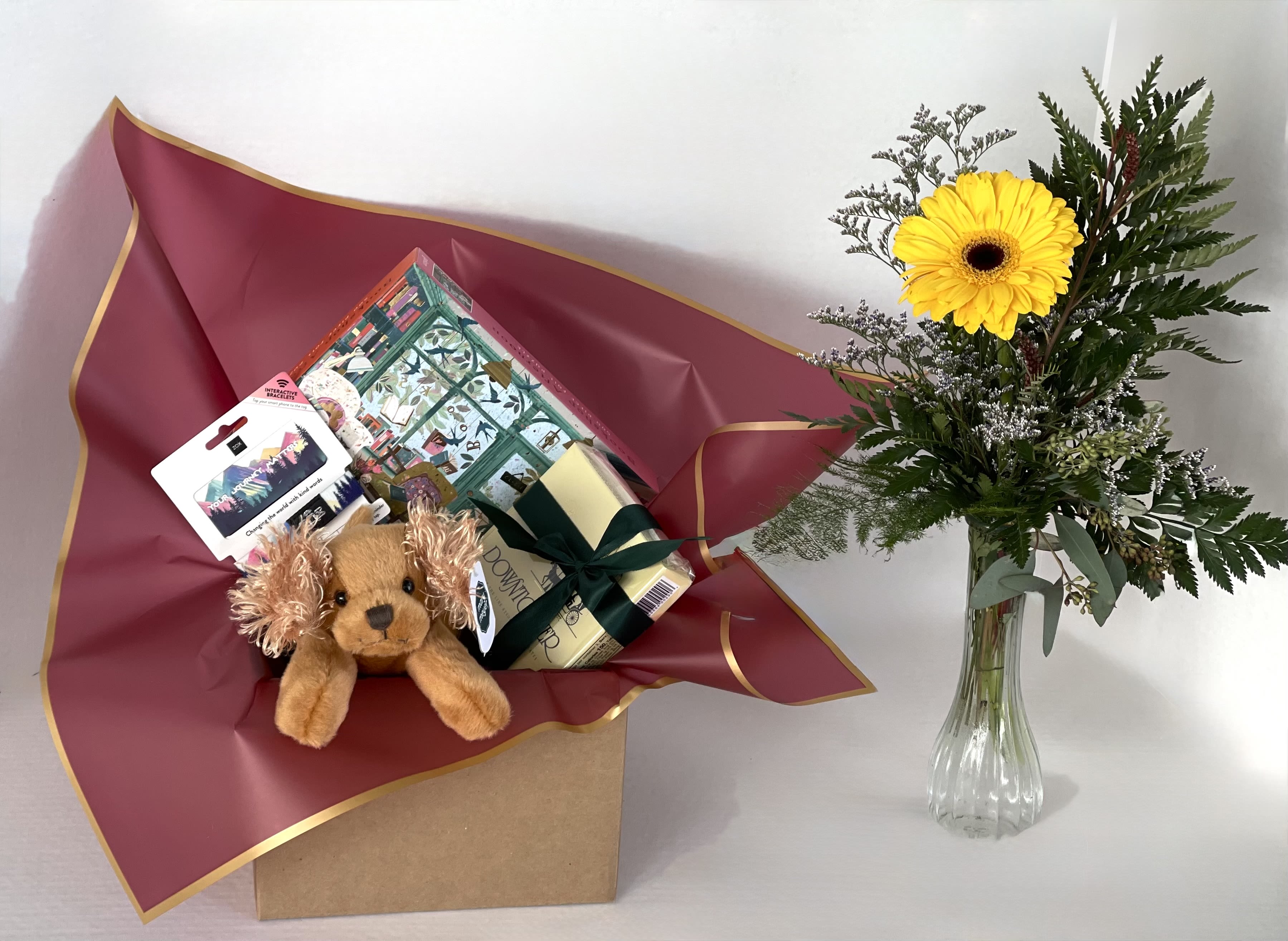 Gift basket with a plush dog and a yellow gerbera daisy in a vase