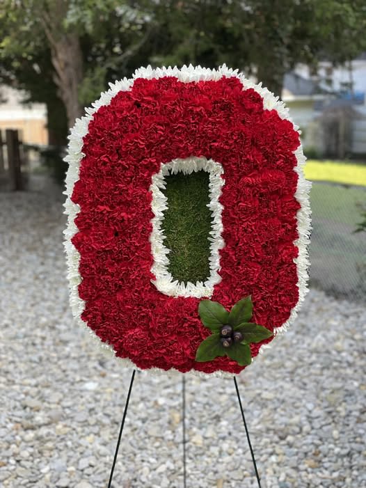 Red and white floral standing tribute shaped like a letter O