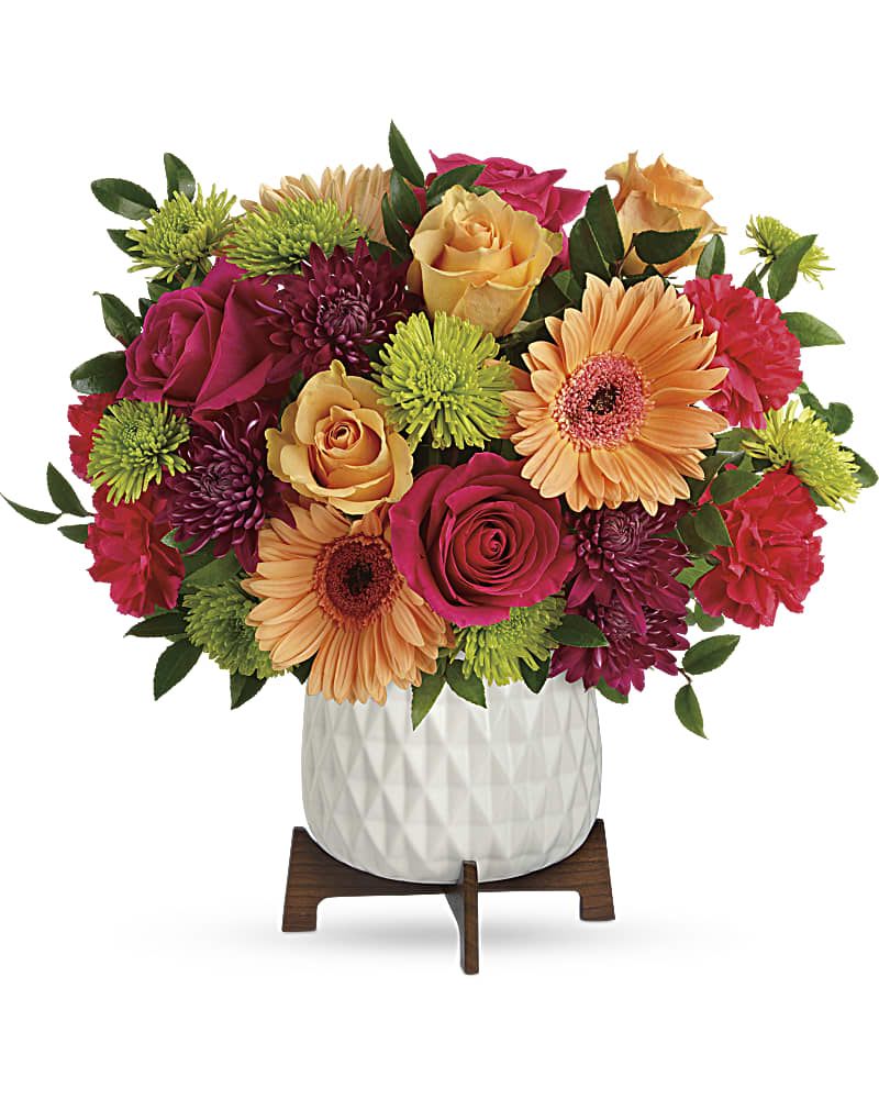 Bright mixed bouquet in a white vase on a wooden stand