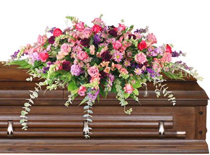 Pink and purple floral spray on a wooden casket