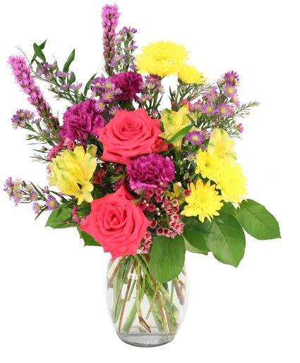 Mixed bouquet of pink roses, yellow daisies, and purple flowers in a glass vase