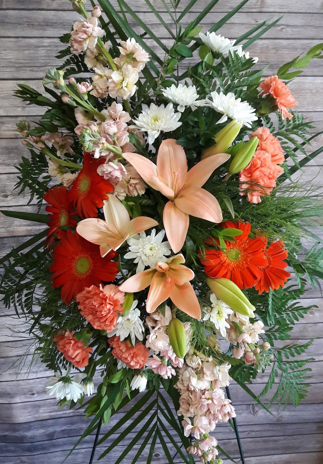 Mixed bouquet with orange gerberas, peach lilies, and white daisies