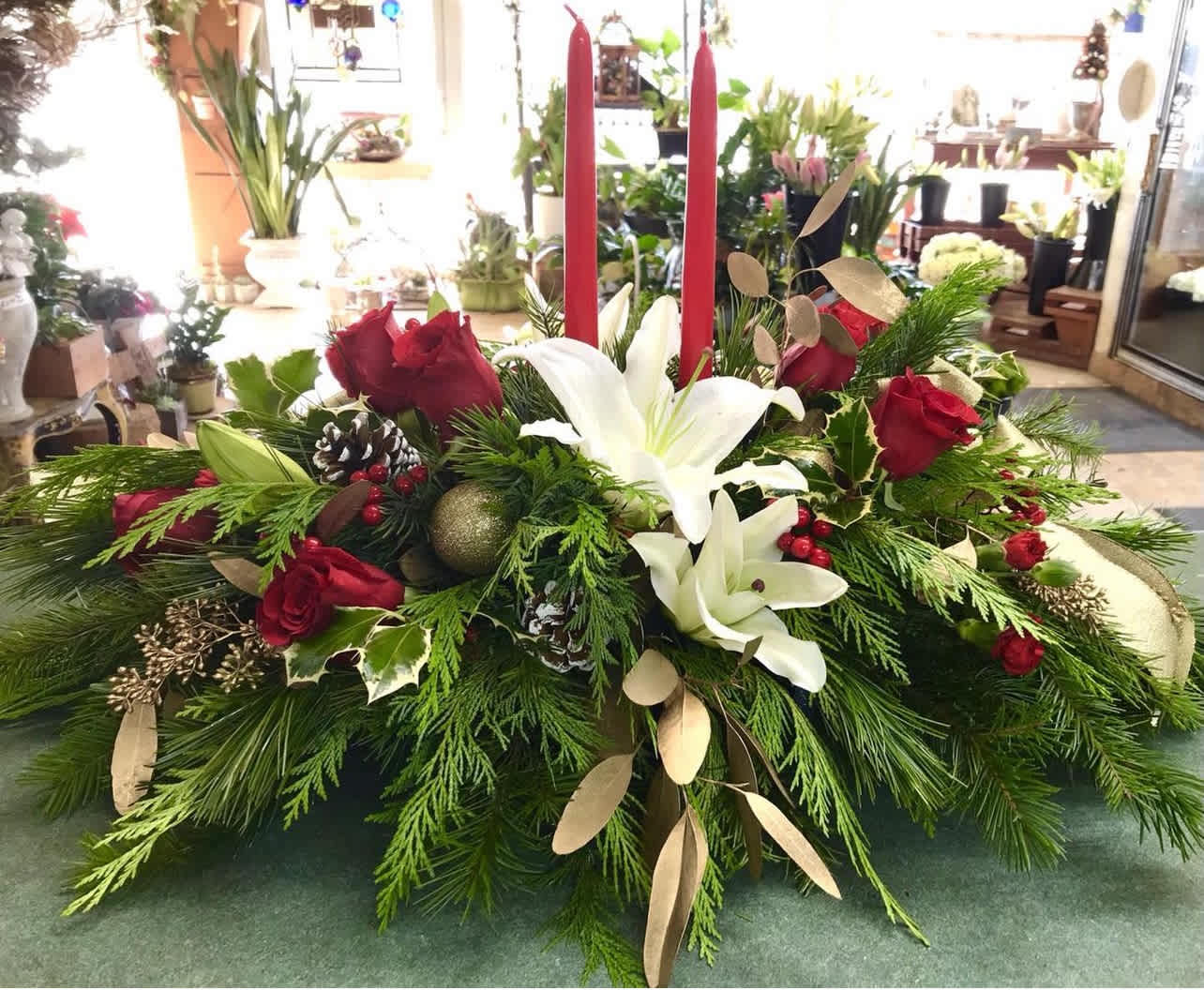 Holiday Centerpiece - Beautiful and classic holiday centerpiece accented with fresh flowers, pine cones, ornaments and 2 candle sticks.