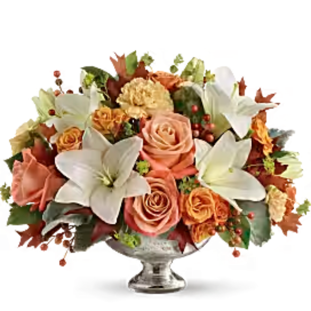 Peach roses and white lilies arranged in a clear glass vase