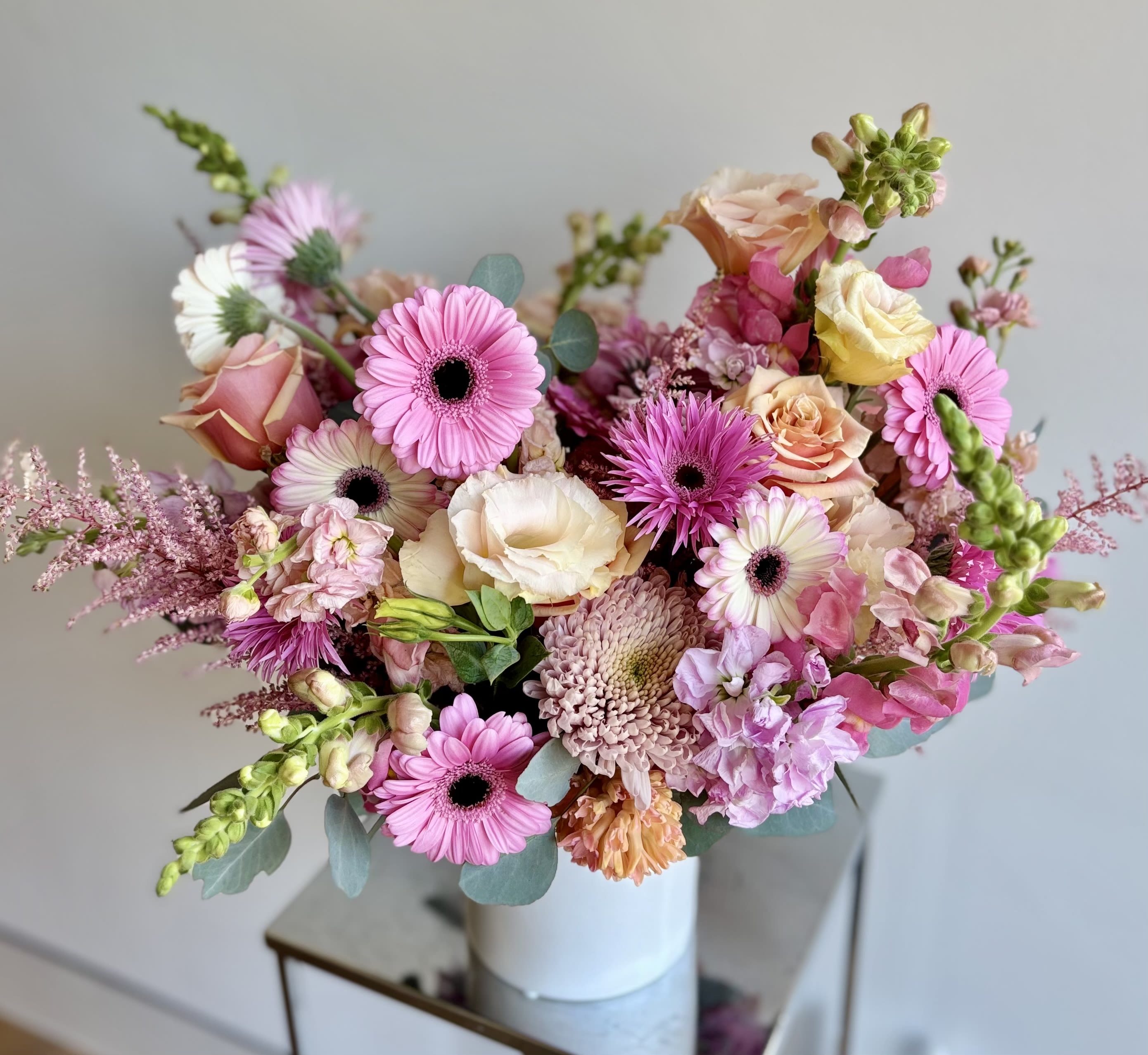 Peach Kiss - A romantic mix of peachy pink blooms, thoughtfully arranged for your love one. Featuring premium flowers such as roses, snapdragons, lisianthus, hyacinths, stock, gerbers, and cremons, and more....
