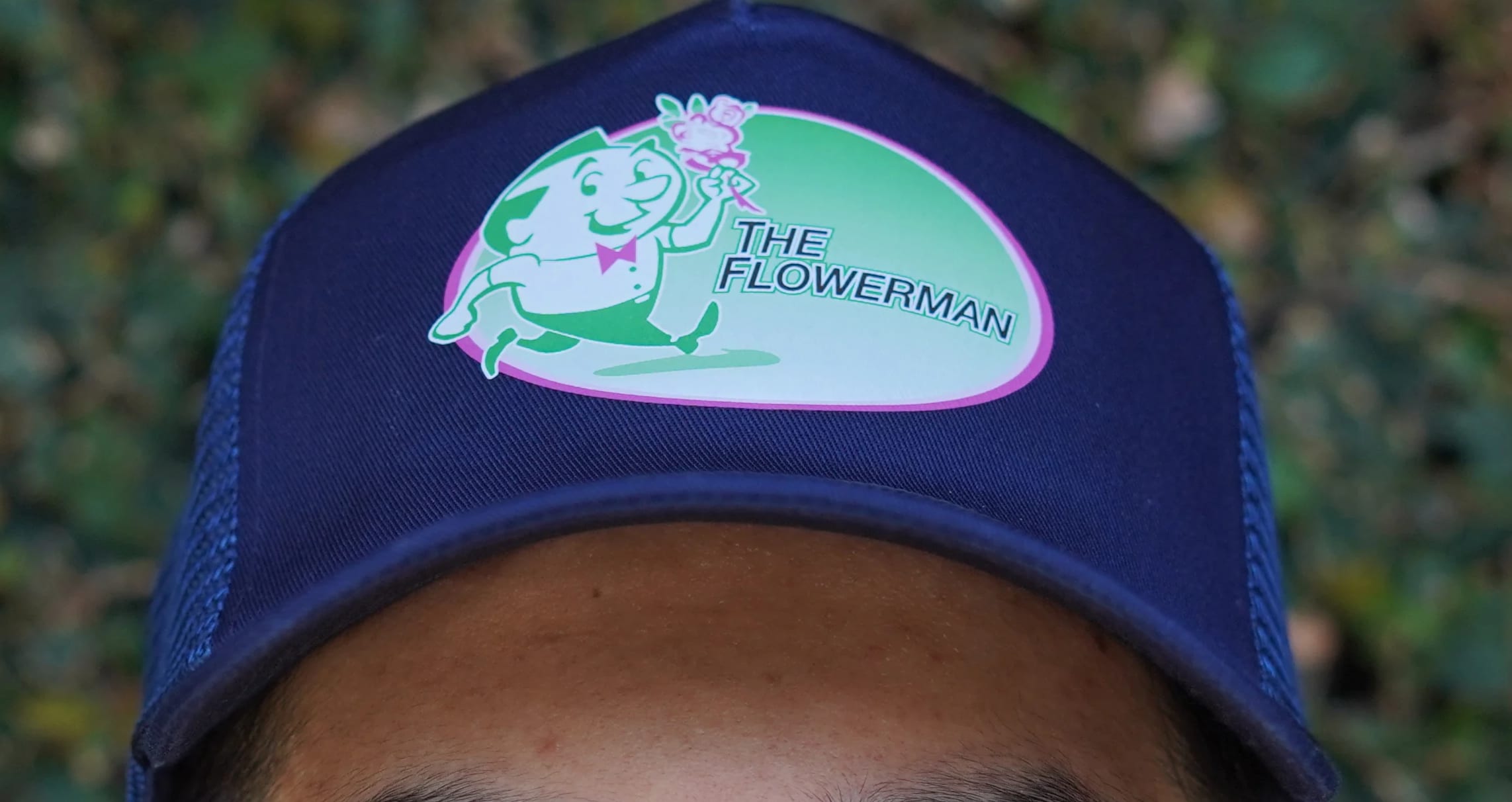 "The Flowerman" Logo Hat - Introducing the all-new "The Flowerman" hat! A heartwarming creation by "The Flowerman" florist. This shirt is not just an apparel piece; it's a symbol of love and support for your local business. Embrace style and community spirit with every step you take!  Crafted with care and attention to detail, the "The Flowerman" hat offers an unparalleled level of comfort with its breathable fabric in the back of the hat. The sturdy brim and soft lining makes it perfect for any weather, keeping you cool and fresh throughout the day. Designed to showcase your admiration for our small business, this hat features "The Flowerman" florist's iconic mascot on the front in many beautiful colors!  Spread the love and join "The Flowerman" florist in celebrating the beauty of community with this hat. Together, let's blossom into a future where small businesses thrive, and our neighborhoods flourish with love and solidarity.