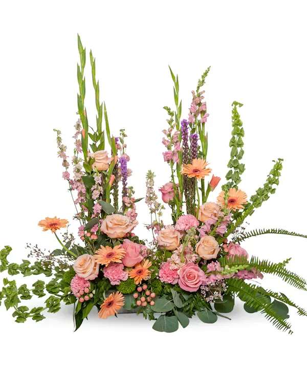 Pink and peach floral arrangement with tall green spikes and orange daisies