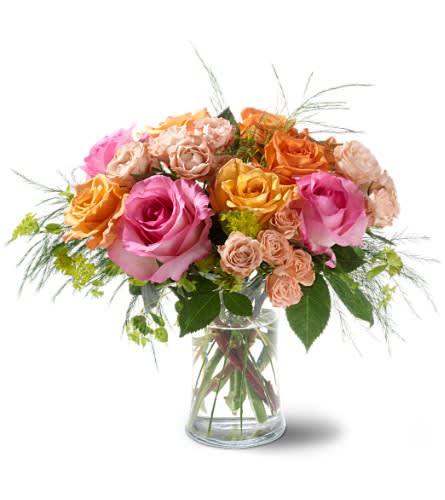 Teleflora's Garden of Roses - If you wander through a fragrant garden remember to stop and smell the roses. This bountiful bouquet of mixed roses in glamorous sunset colors of pink and coral is sure to delight the senses. A clear glass vase featuring a mix of orange and bright orange roses plus pink roses and spray roses accented by tree fern and bupleurum.Approximately 14" (W) x 12" (H) Orientation: All-Around As Shown : TF-WEB26