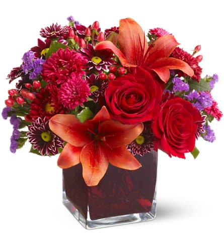 Teleflora's Autumn Grace - Roses lilies and asters in precious gemstone colors of garnet are nestled into a richly colored plum glass cube vase creating a graceful presentation. Purple chrysanthemums and seafoam statice add a special touch. A beautiful bouquet for any occasion! Red roses Asiatic lilies Matsumoto asters and hypericum; purple daisy spray chrysanthemums and seafoam statice are delivered in a plum glass Teleflora cube vase. Approximately 11" (W) x 10" (H) Orientation: All-Around As Shown : TFWEB232