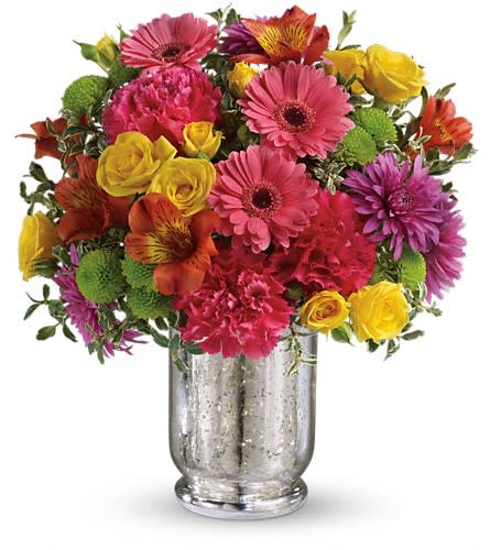 Teleflora's Pleased As Punch Bouquet - Like a glass of party punch this juicy bouquet of bold pink yellow and purple flowers will refresh and revitalize your lucky someone. Arranged in a shimmering Mercury Glass hurricane it's one sweet treat! Yellow roses pink gerberas orange alstroemeria hot pink carnations green button chrysanthemums and purple cushion spray chrysanthemums are accented with oregonia. Delivered in a Mercury Glass hurricane.Approximately 11 1/2" W x 12 3/4" H Orientation: One-Sided As Shown : TEV31-1ADeluxe : TEV31-1BPremium : TEV31-1C
