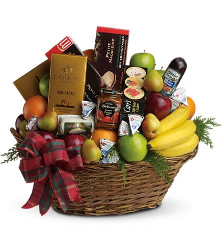 The Ultimate Christmas Basket - The ultimate crowd pleaser this basket is simply overflowing with deliciousness. It's sure to make a big impression on anyone from the boss to friends and family. It holds all kinds of fresh fruit - from apples and pears to bananas and oranges - gourmet chocolates and cookies cheeses sausages crackers and more. Plus it's all wrapped and ribboned in a big delightful basket. Let the sumptuous snacking begin!Approximately 22" W x 21" H Please note: All of our bouquets and gift baskets are hand-arranged and delivered locally by professional florists. This item may require additional lead time so same-day delivery is not available. Orientation: N/A As Shown : T135-3ADeluxe : T135-3BPremium : T135-3C