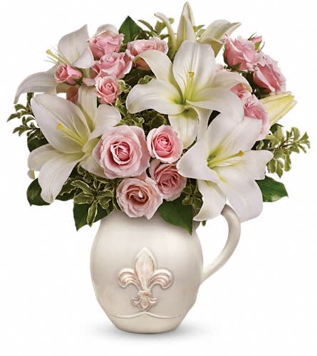 Teleflora's Fleur-de-Love Bouquet - Capture the grace of Grandparents Day. Charming pink roses and fresh white asiatic lilies are nestled in our classic Fleur-de-Love Pitcher. A fleur-de-lis motif gives a classic flair to this pitcher - the newest addition to our French Country Collection. This bouquet boasts a beautiful display of light pink roses and soft white asiatic lilies accented with lemon leaves and pitta negra. Delivered in a handcrafted ceramic French country pitcher.Approximately 13" W x 14" H Orientation: One-Sided As Shown : T12G100ADeluxe : T12G100BPremium : T12G100C