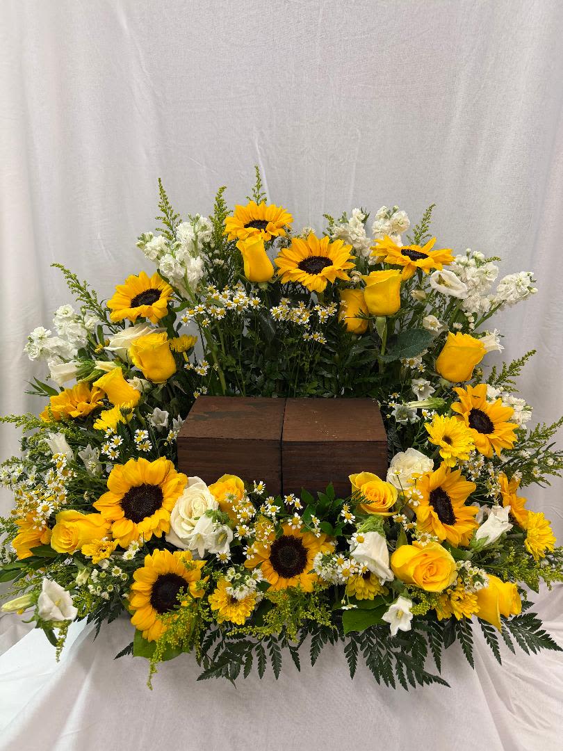 A RAY OF LIGHT - A BEAUTIFUL CREATION OF SUNFLOWERS, YELLOW ROSES, STOCK, FILLER. THIS ARRANGEMENT IS TO HAVE A URN PLACED IN THE MIDDLE. THIS CAN BE OF ANY SIZE URN. COLORS CAN CHANGE ON THE FLOWERS IF NEEDED