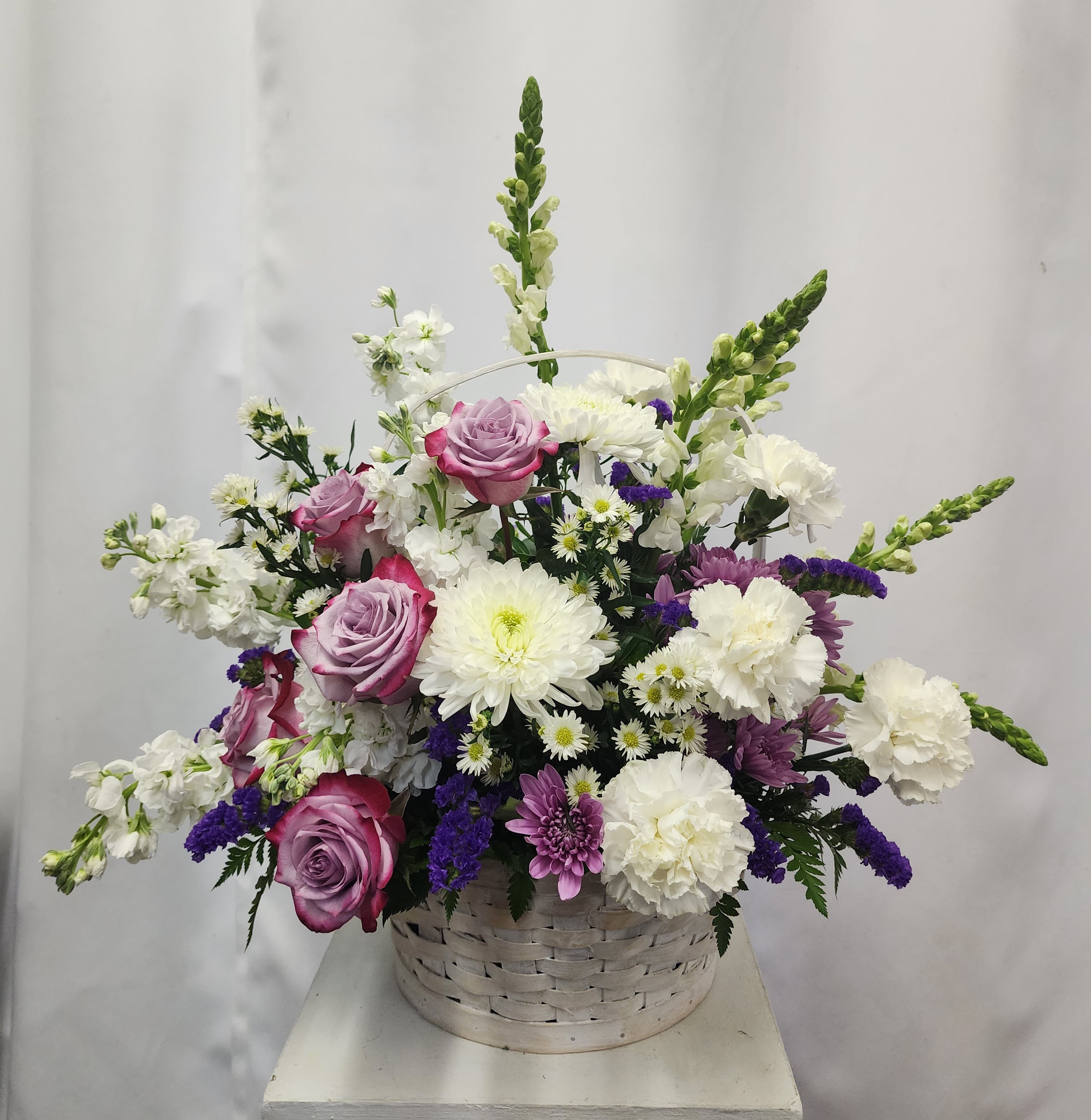 Lavender Serenity Basket - Offer comfort and heartfelt condolences with the Lavender Serenity Basket, a beautifully crafted sympathy arrangement designed to bring peace, comfort and hope to those experiencing loss. This elegant basket has a blend of lavender and white blooms, featuring lavender and white roses, stock, carnations, snapdragons, cushions, and cremones. Each flower is chosen for its soothing colors and symbolic meaning. It's an elegant gesture of heartfelt condolence. Ideal for Funeral services, memorials or for sending support to grieving families.  