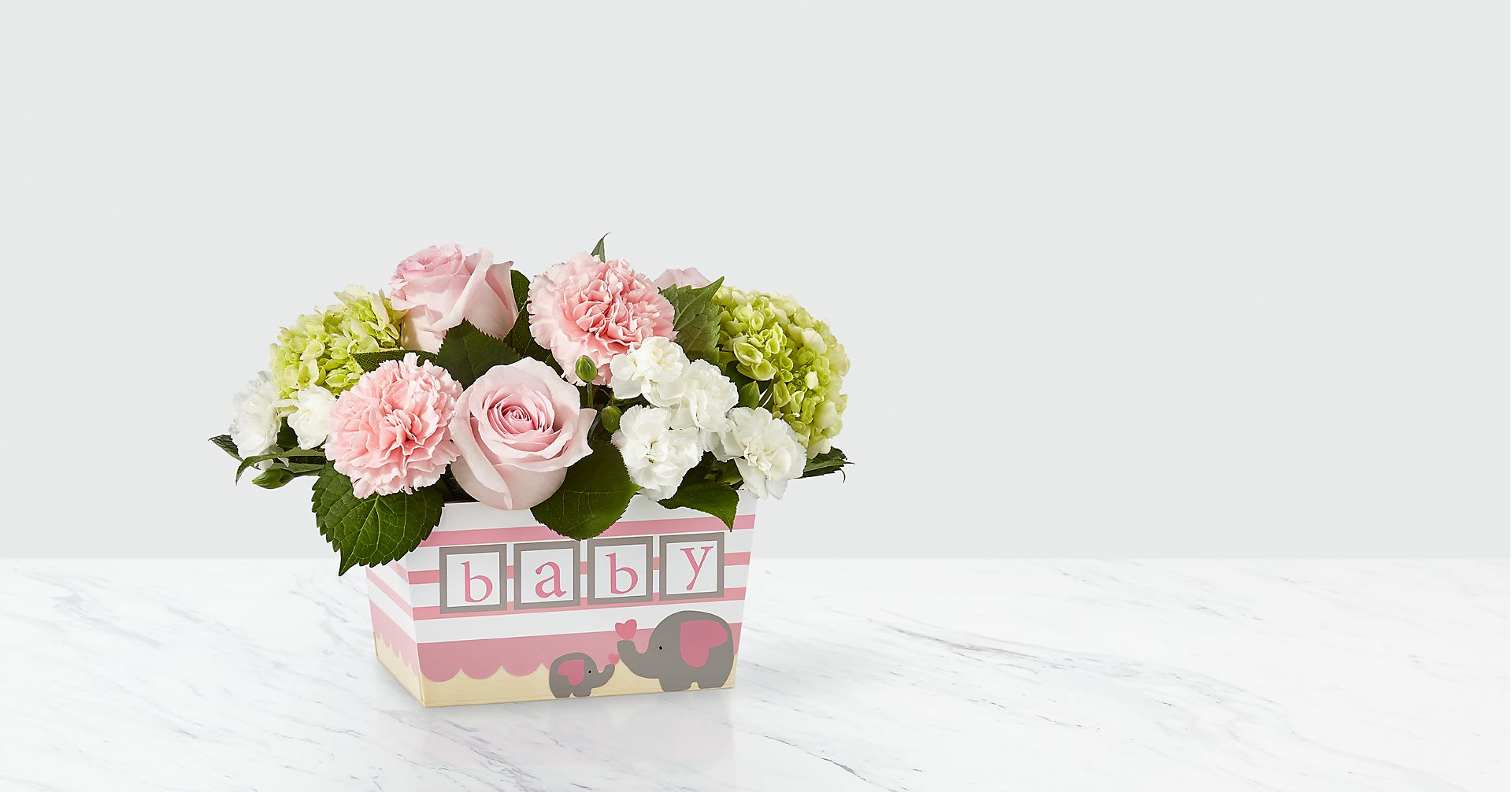 Pink and white flower arrangement in a baby-themed box