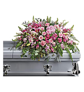 Pink and white floral spray on a silver casket