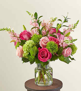 Pink and green mixed bouquet in a clear glass vase
