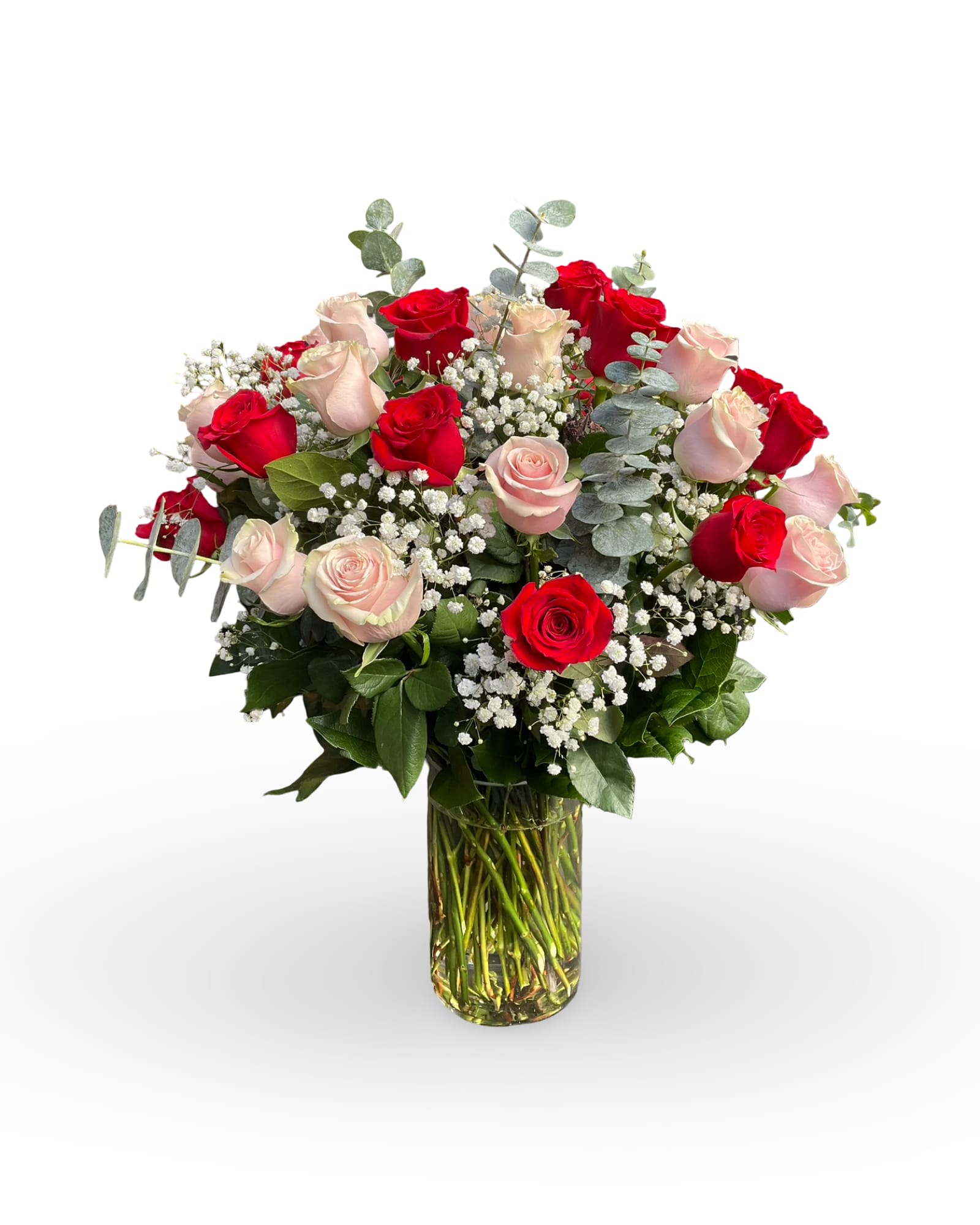 Red and blush roses arranged in a clear glass vase