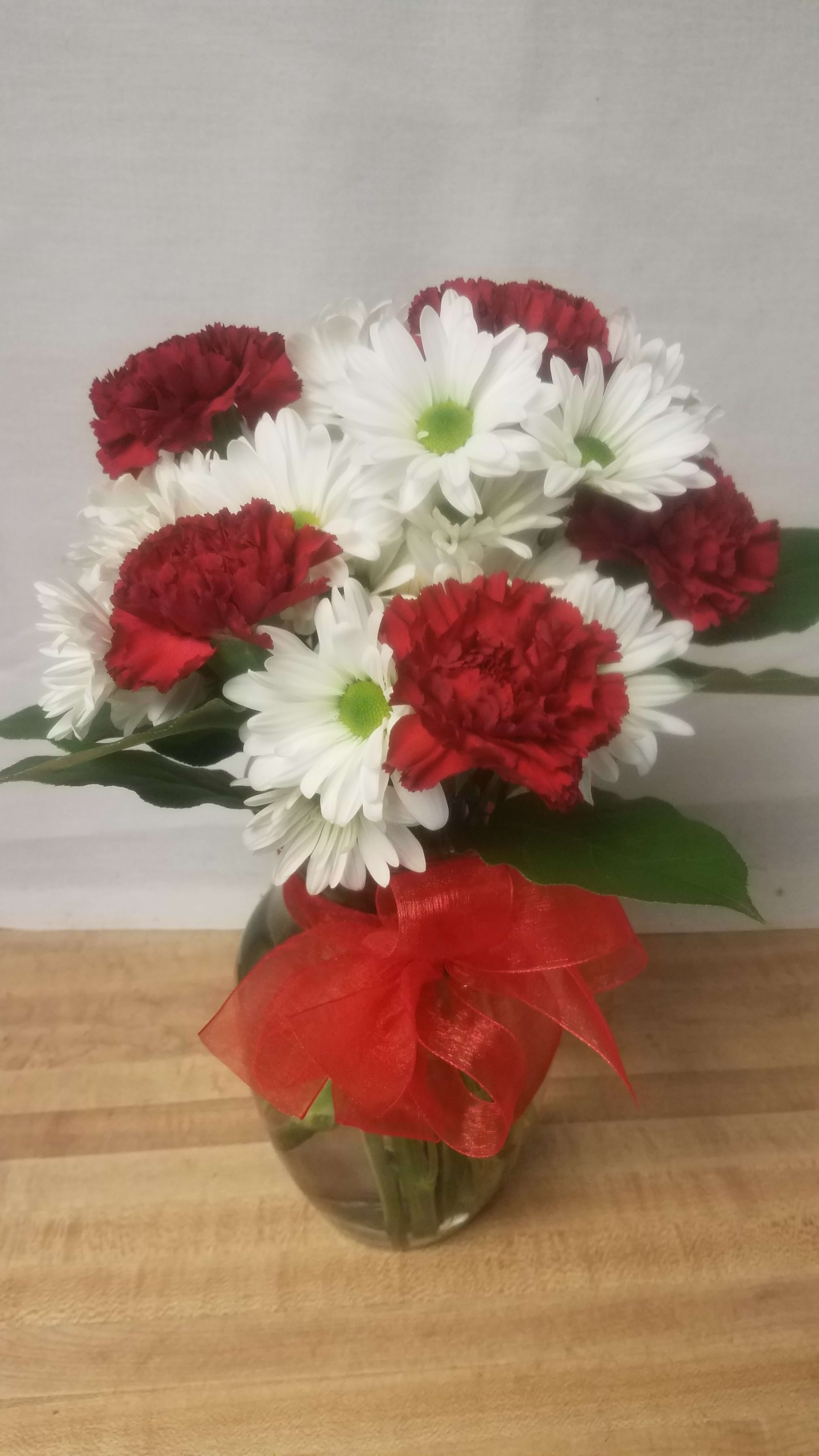 Kindness Bouquet - A special show of kindness any day of the year! This eye-catching arrangement of red carnations and white daisies will surprise and delight your special someone - and remain a treasured memory for years to come.