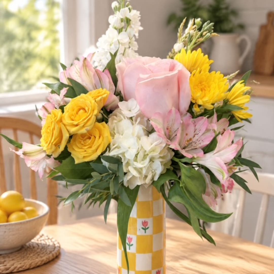 Pink and yellow mixed bouquet in a checkered vase