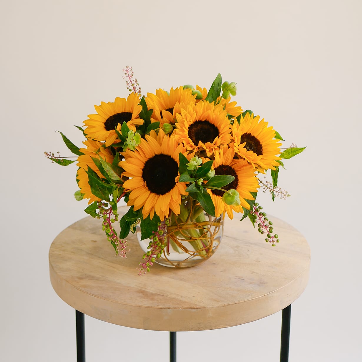 Sunflower arrangement in a clear glass vase on a round table