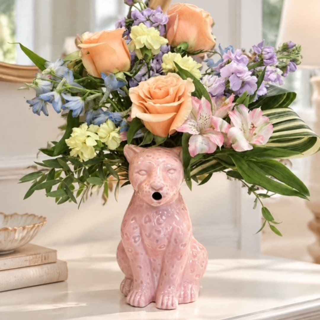 Mixed pastel flower arrangement in a pink leopard-shaped vase