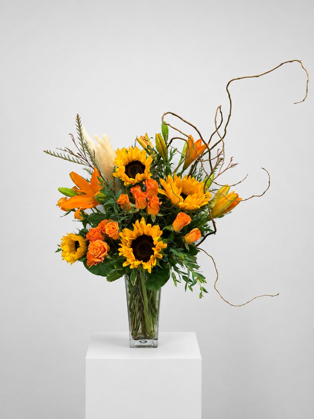 Orange and yellow floral arrangement in a clear glass vase