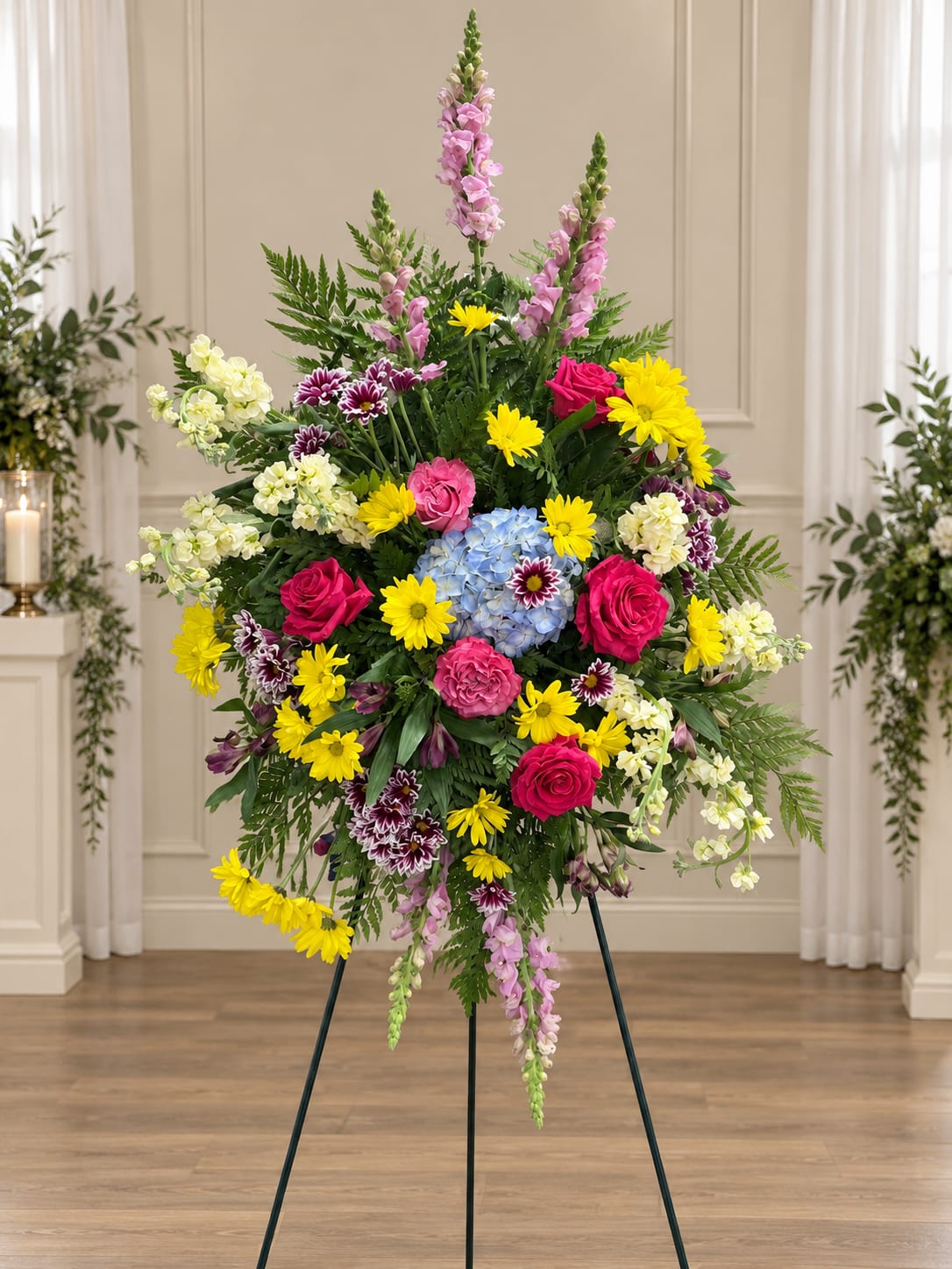 Tall standing floral spray with pink, yellow, blue, and white flowers