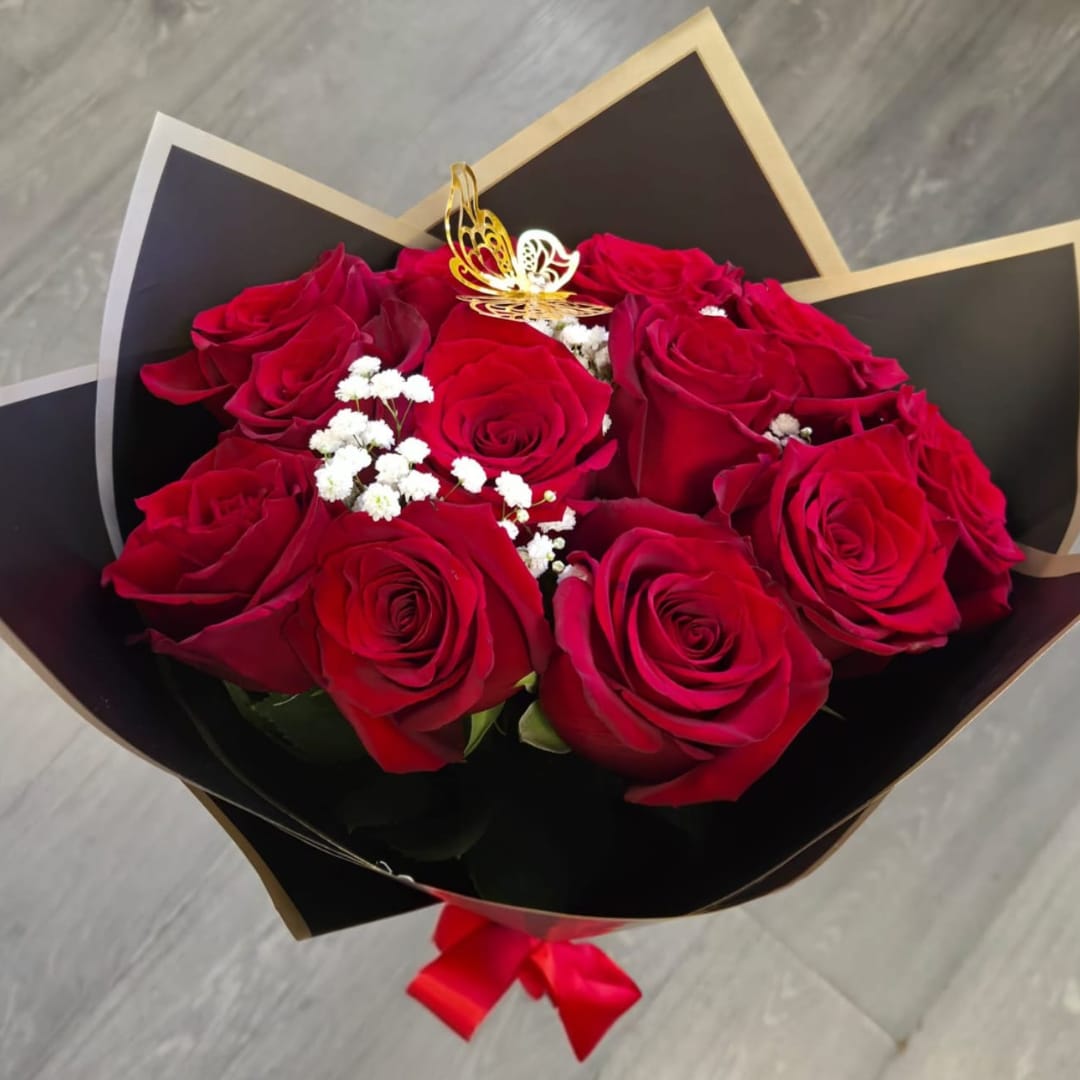 Bouquet of red roses wrapped in black paper with a red ribbon